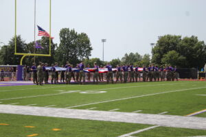 Tech ROTC students begin stretching out a large flag over Tech's football field.