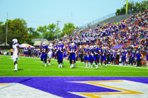 Tech football players jog onto the field for an offensive possession.